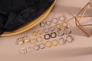 Collezione di orecchini a cerchio minimalisti in oro e argento su vassoio in metallo