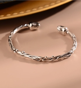Detail view of retro silver flower bracelet featuring branch textures and vintage oxidized finish