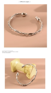 Detailed views of vintage silver rose bangle with vine textures on pink background