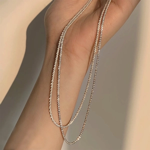 Sparkling silver star-inspired necklace worn on hand with soft elegant shadows
