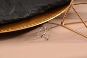 Dettaglio di orecchini a cerchio in argento con design a catena su vassoio decorativo