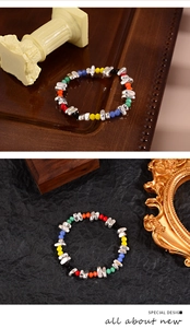 Detailaufnahme von Regenbogenperlen-Armband mit silbernen Akzenten auf Dekohintergrund
