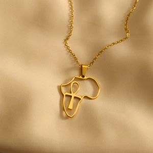 Golden stainless steel Africa map pendant necklace with Ankh cross on satin background
