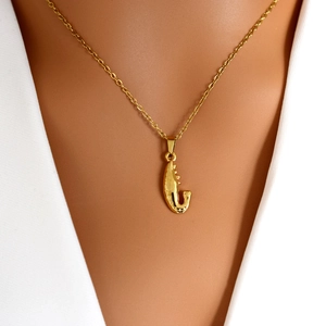 Minimalistische gouden ketting met getextureerde garnaalhanger gedragen door een model
