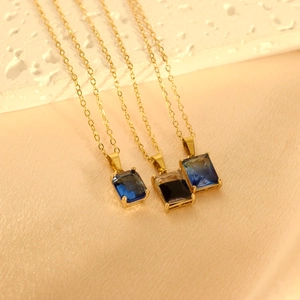 Minimalistische geometrische Anhänger mit blauen und schwarzen Steinen an Goldketten