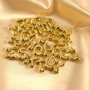 Minimalist golden puffy 26 English alphabet pendants set on premium silk background