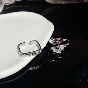 Detailed view of silver dragon ring with pink eye and lava texture open ring set