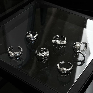 Detailed view of silver adjustable rings featuring pearls and irregular textures