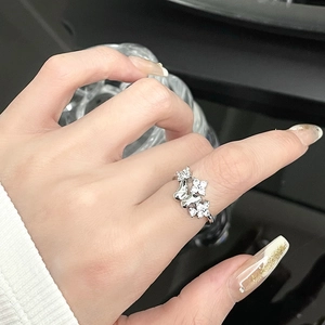 Detail of silver butterfly and floral ring with cubic zirconia on a female finger
