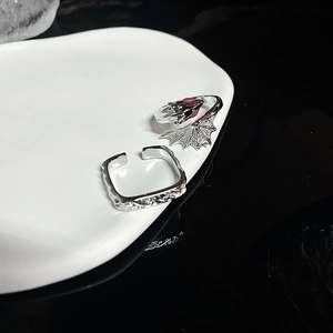 Retro dragon wing and textured square silver open rings on a stylish white ceramic tray