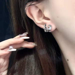 Detailed view of silver octopus stud earring featuring a luminous moonstone on the ear