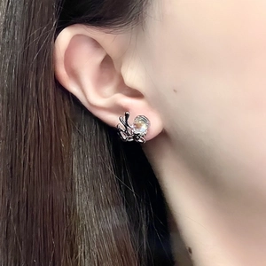 Close-up of moonlight stone rabbit ear stud showing elegant claw design and texture