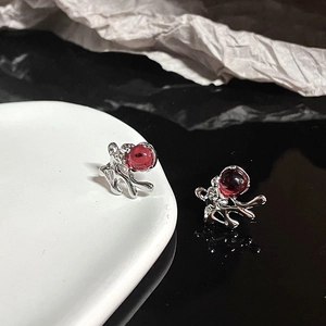 Detailed macro view of silver rabbit stud earring with round red gemstone inlay