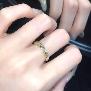 Details eines goldfarbenen Kordelrings mit Pavé-Besatz und eleganter Spiegelreflexion