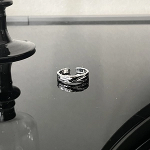 Minimalist silver open cuff ring with irregular lava texture and industrial metal finish