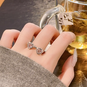 Unregelmäßiger silberner offener Ring mit zwei rosa Herz-Edelsteinen an der Hand