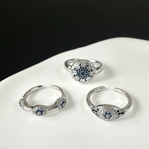 Macro shot of silver adjustable rings featuring blue devil's eye and zircon star motifs