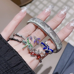 Enamel bow rings and textured silver cuff bracelet set on female hand model
