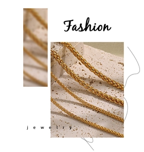 Detail of four assorted thickness gold PVD wheat chains on a natural stone base