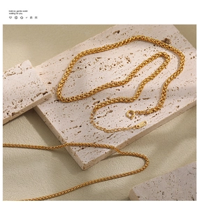 Detailed macro view of 18KGP gold plated wheat chain with lobster clasp on stone