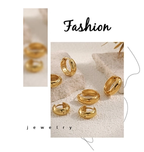 Polished gold hoop earrings in various sizes arranged on a natural stone background