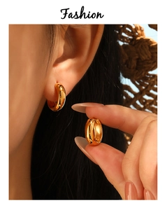 Detailed close-up of polished golden stainless steel huggie hoop earrings for women