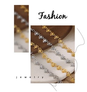 Primer plano de collares de cadena con eslabones de corazón en oro y plata grabados