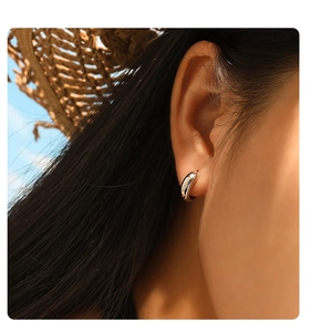 Close-up of minimalist high-polished stainless steel chunky hoop earring on a model