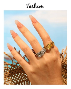 Detailansicht unregelmäßiger Lavatextur-Ringe in Gold und Silber auf der Hand