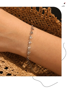 Primer plano detallado del collar de corazones plateados con grabado de sol