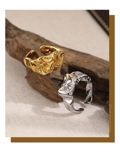 Details von gold- und silbernen Ringen mit Knitterstruktur auf einem Ast