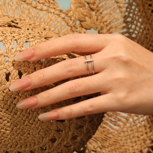 Minimalist double layer silver ring with pavé crystals on hand with sunlit hat background
