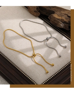 Detalle de tobilleras de cadena de serpiente ajustables en oro y plata con cierre deslizante