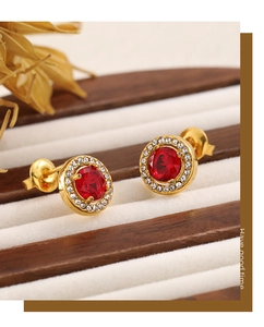 Detailed close-up of vintage gold earrings with red ruby stone and halo diamonds
