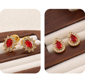 Detail view of oval and teardrop red ruby studs with gold stainless steel plating