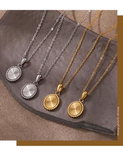 Detail of laser-etched oval necklaces in gold and silver with textured radial centers