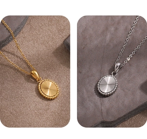 Detail of oval sunburst pendant necklaces in gold and silver on natural stone background