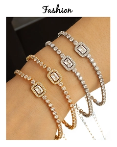 Detail of layered gold and silver tennis bracelets with rectangular halo crystals on wrist
