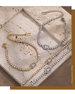 Detail of gold and silver square halo tennis bracelets with K18L tag on stone base