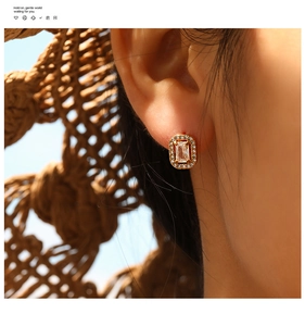 Close-up of vintage 18K gold plated earring with rectangular ruby and pavé diamonds