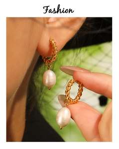 Détail de boucles d'oreilles torsadées en or avec perles d'eau douce sur mannequin