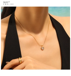 Close-up of a 18K gold-plated heart pendant necklace with shimmering zircon stones