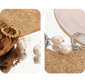 Détail des boucles d'oreilles perles torsadées en or et argent sur un fond de plage naturel