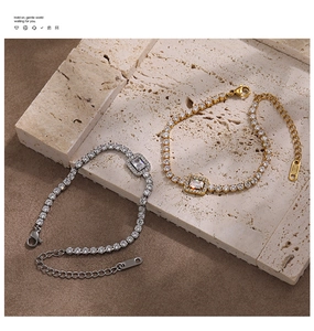 Detail of gold and silver tennis bracelets with central emerald cut cubic zirconia crystals