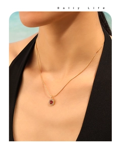 Detail of 18K gold necklace featuring a vintage square red gemstone pendant on a model