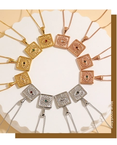 Detail of square eye charm necklaces with colorful zircons on a white display tray