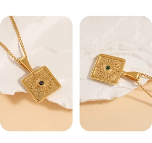 Detail of square evil eye pendants in gold finish with black and green stone inserts