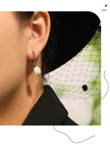 Gros plan de boucles d'oreilles élégantes en perles d'eau douce sur un mannequin