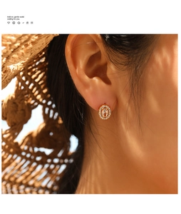 Detail view of vintage 18K gold plated earring with ruby on female model's ear
