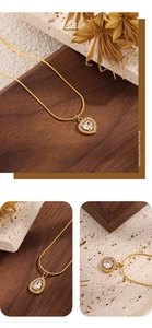Detail of 18K gold heart, pear and round zircon pendants with intricate diamond pavé